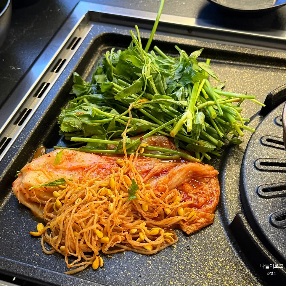 Standard table setting with minari, bean sprouts, and kimchi on the grill