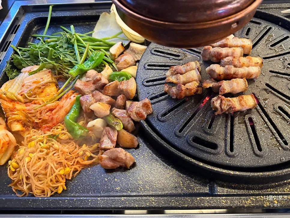 Black pork grilling over a charcoal grill
