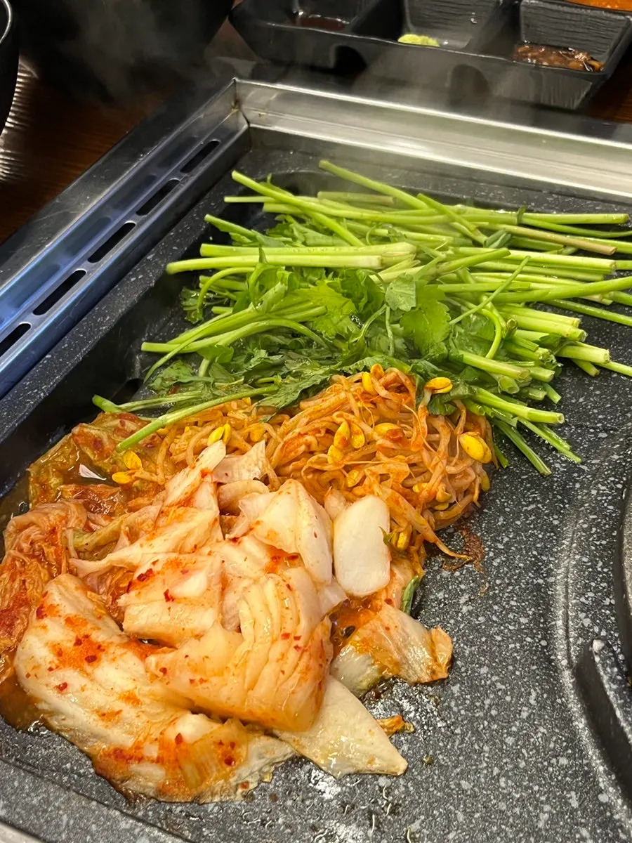 A staff member grilling the meat on the pan