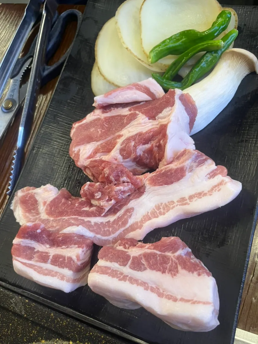 Table set with 2 servings of pork belly at Cham Dwaejitgan Jongno Main Branch