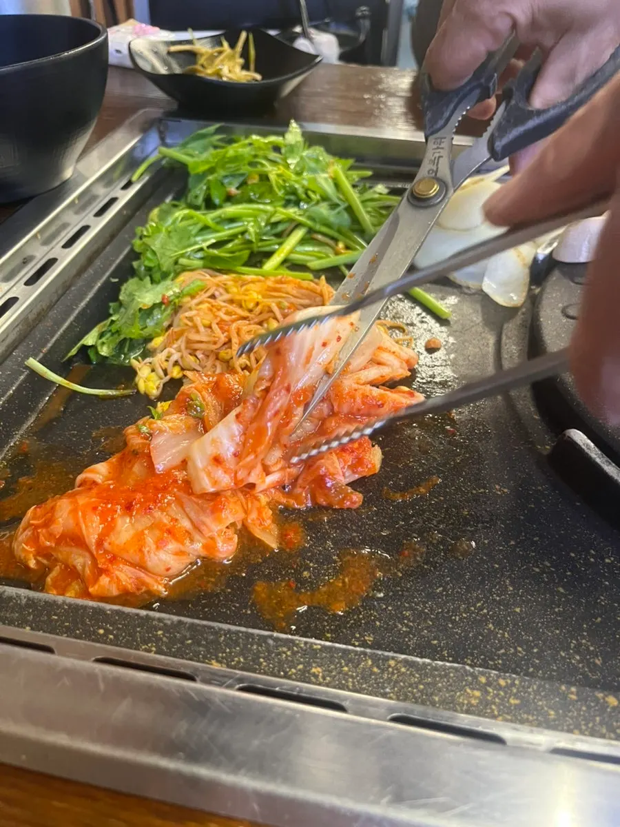 Staff grilling pork belly as part of the grilling service