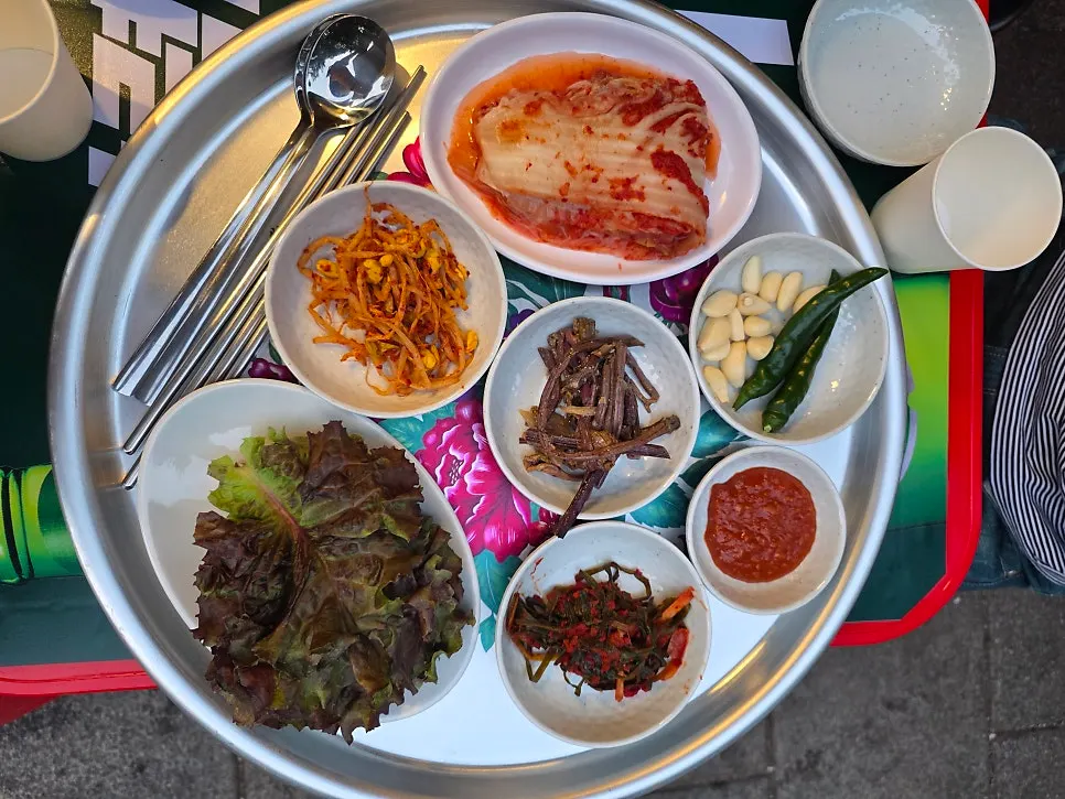 A spread of banchan including lettuce and green onion kimchi
