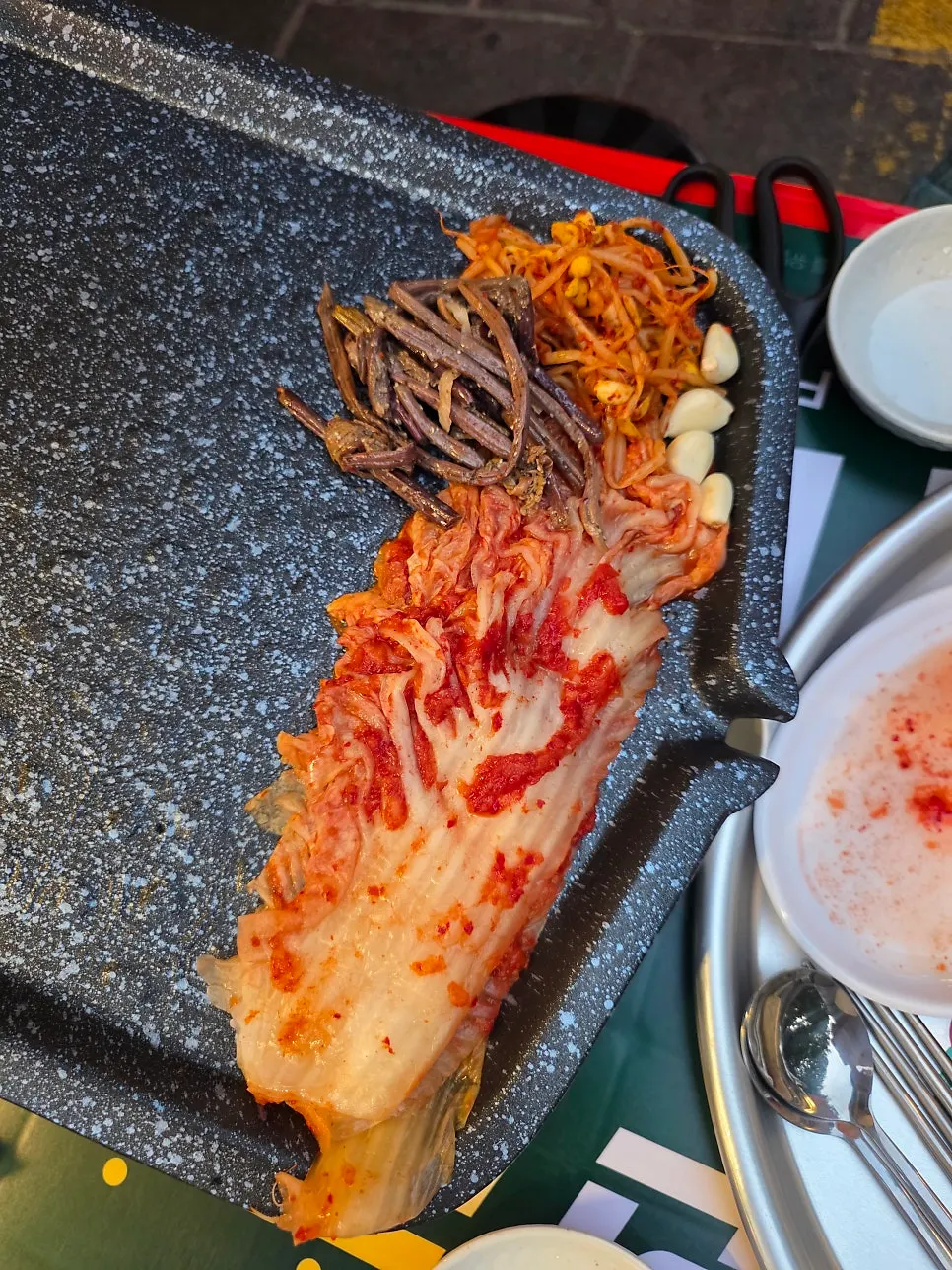 Pork belly on the grill at an outdoor table
