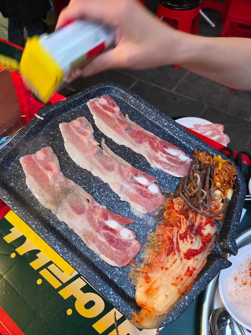Pork belly grilling with pepper sprinkled on top