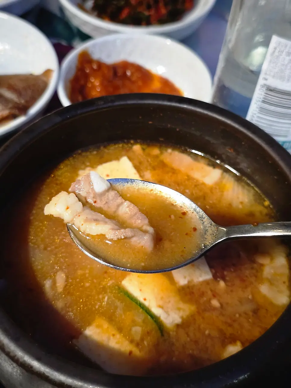 A spoonful of doenjang jjigae broth being scooped up