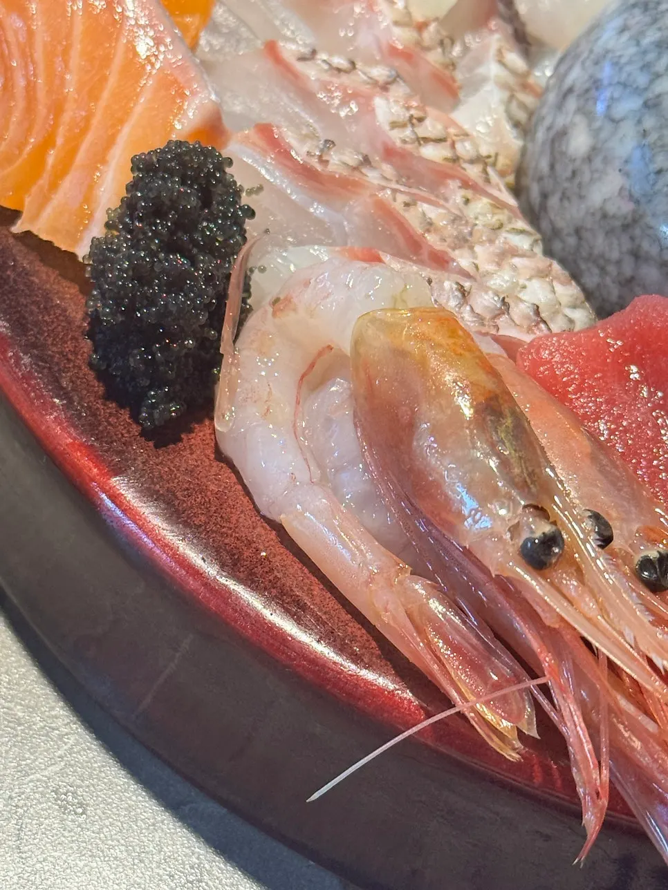 A piece of aged sashimi picked up with chopsticks