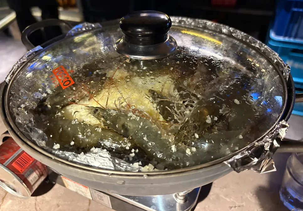 Salt-grilled shrimp arriving at the table