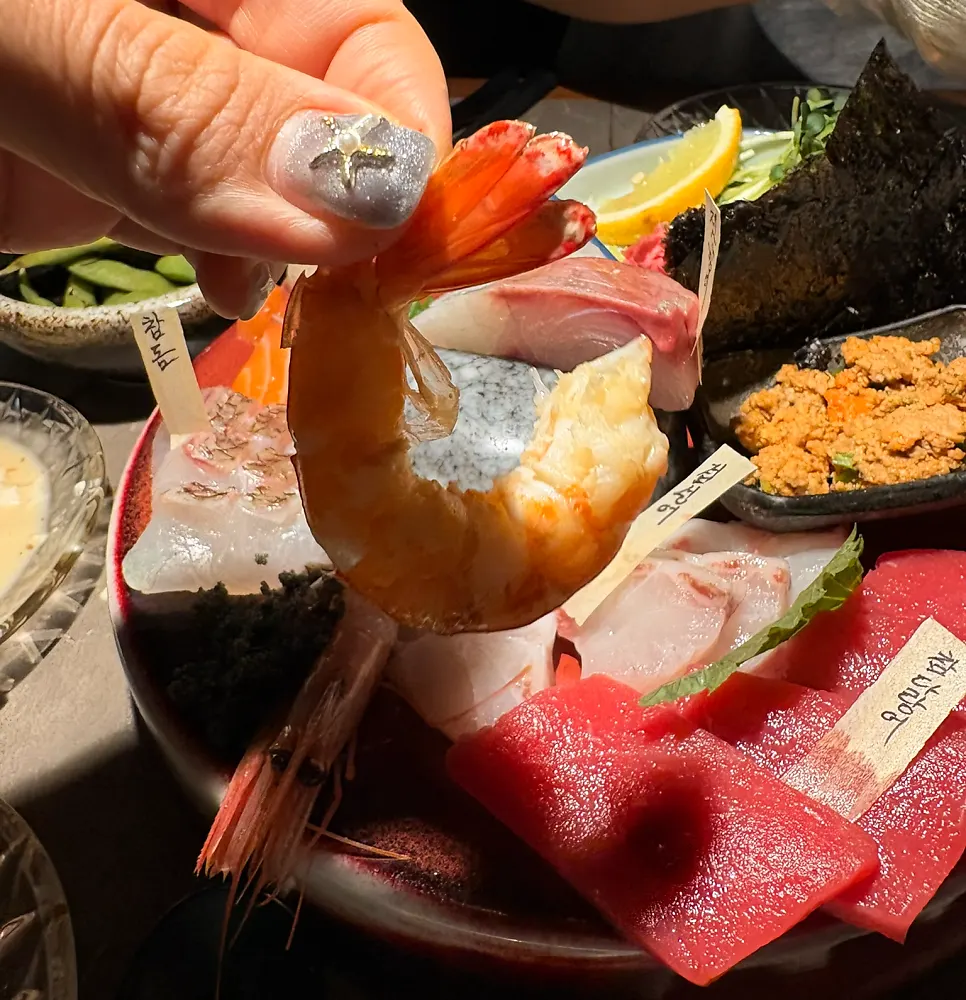 Peeling the shell off a reddened, cooked salt-grilled shrimp