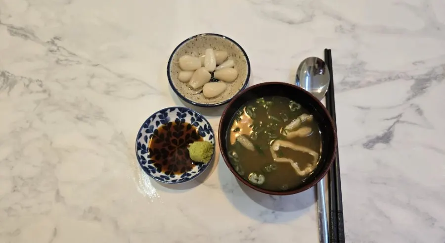Complimentary clear soup and wasabi