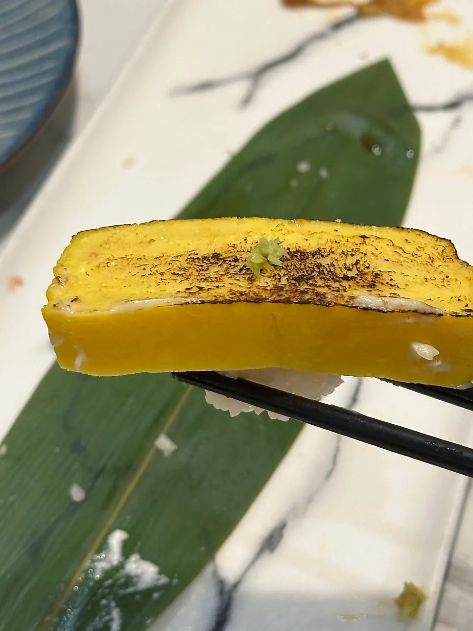 A piece of sushi picked up by hand