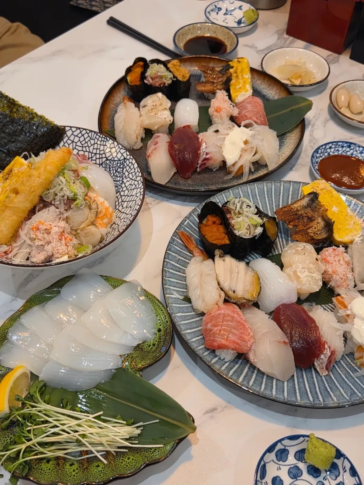 Table spread with sushi, kaisendon, and sashimi