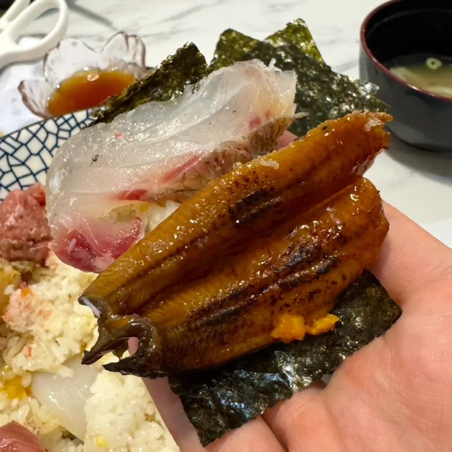 A bite of kaisendon wrapped in seaweed