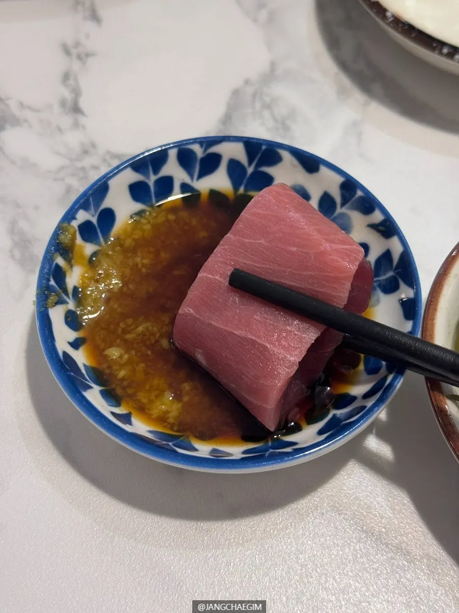 A piece of sashimi dipped in soy sauce