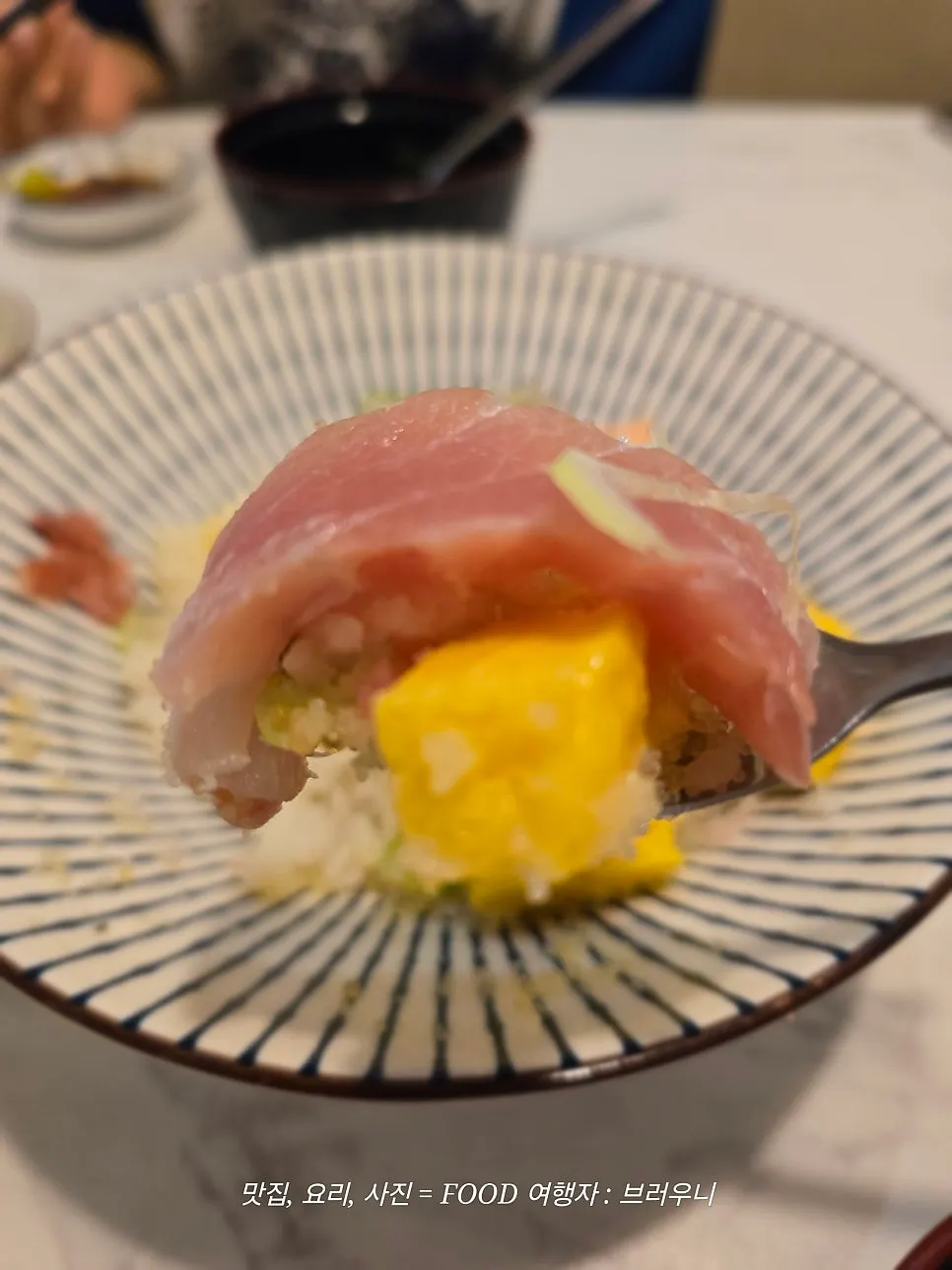 A bite of kaisendon mixed with flying fish roe and rice
