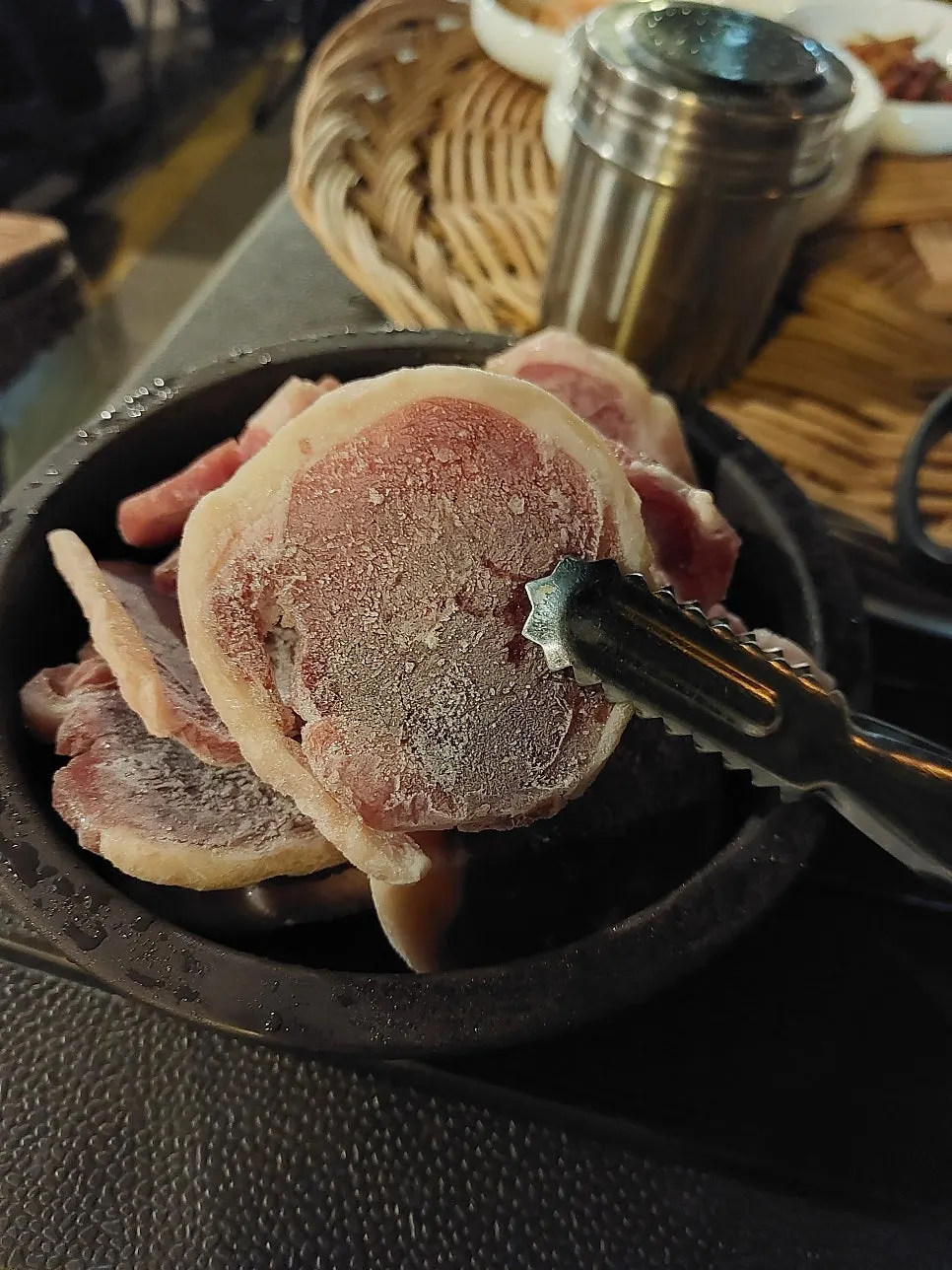Thinly sliced frozen duck roast served in an earthenware crock