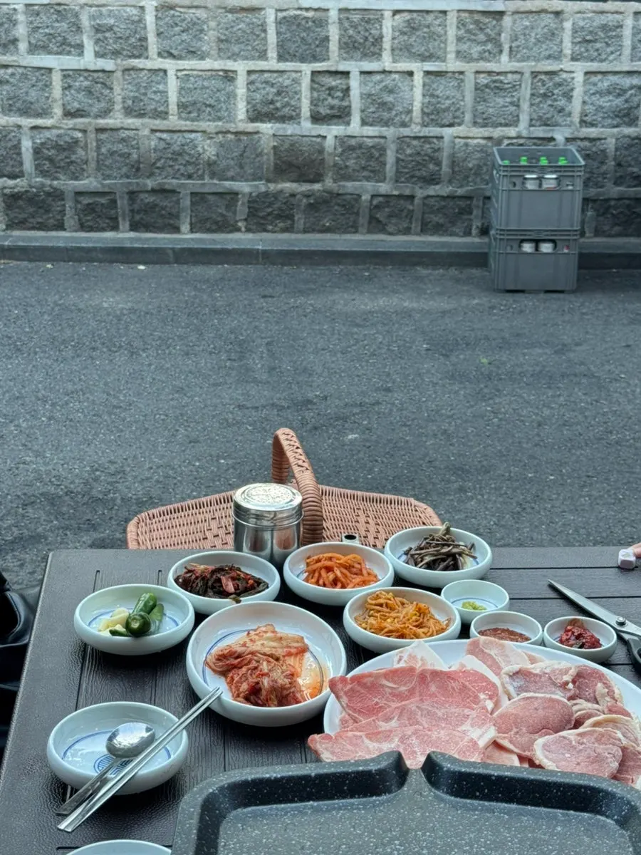 불판에 올린 냉동삼겹살과 김치, 콩나물