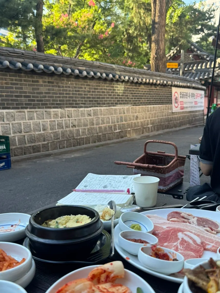 나무와 돌담이 보이는 가을 야장 분위기