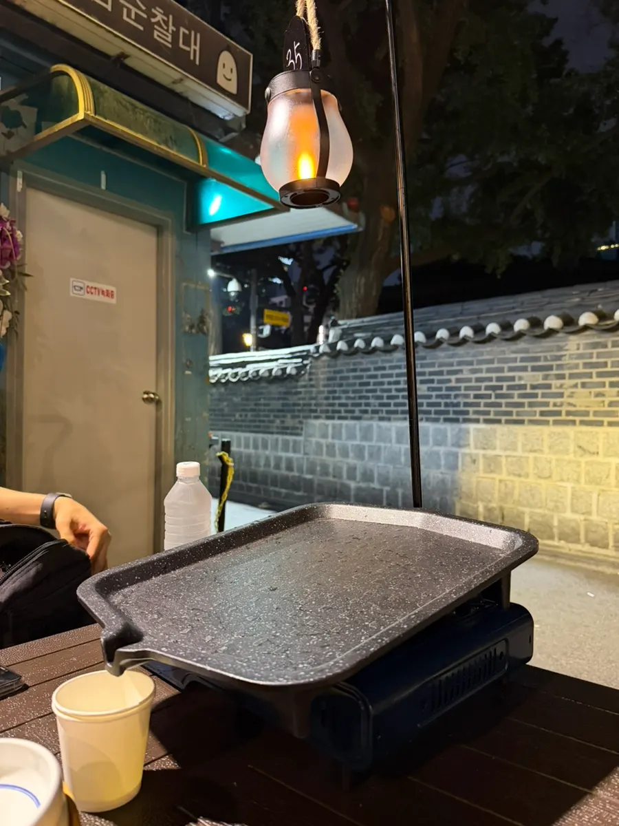 Grilling meat at an outdoor table in Jongno 3-ga