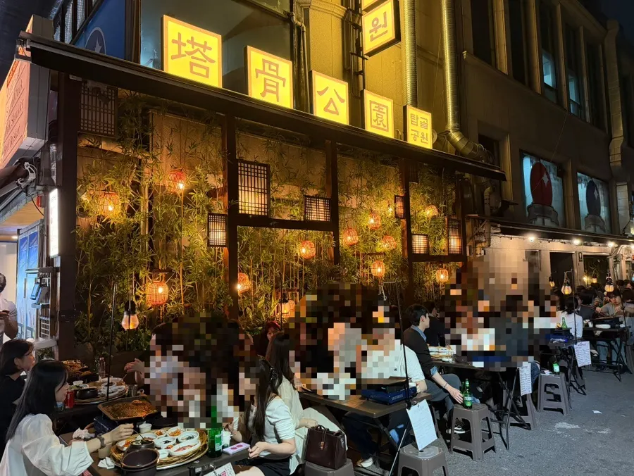 Long row of outdoor tables along the stone wall