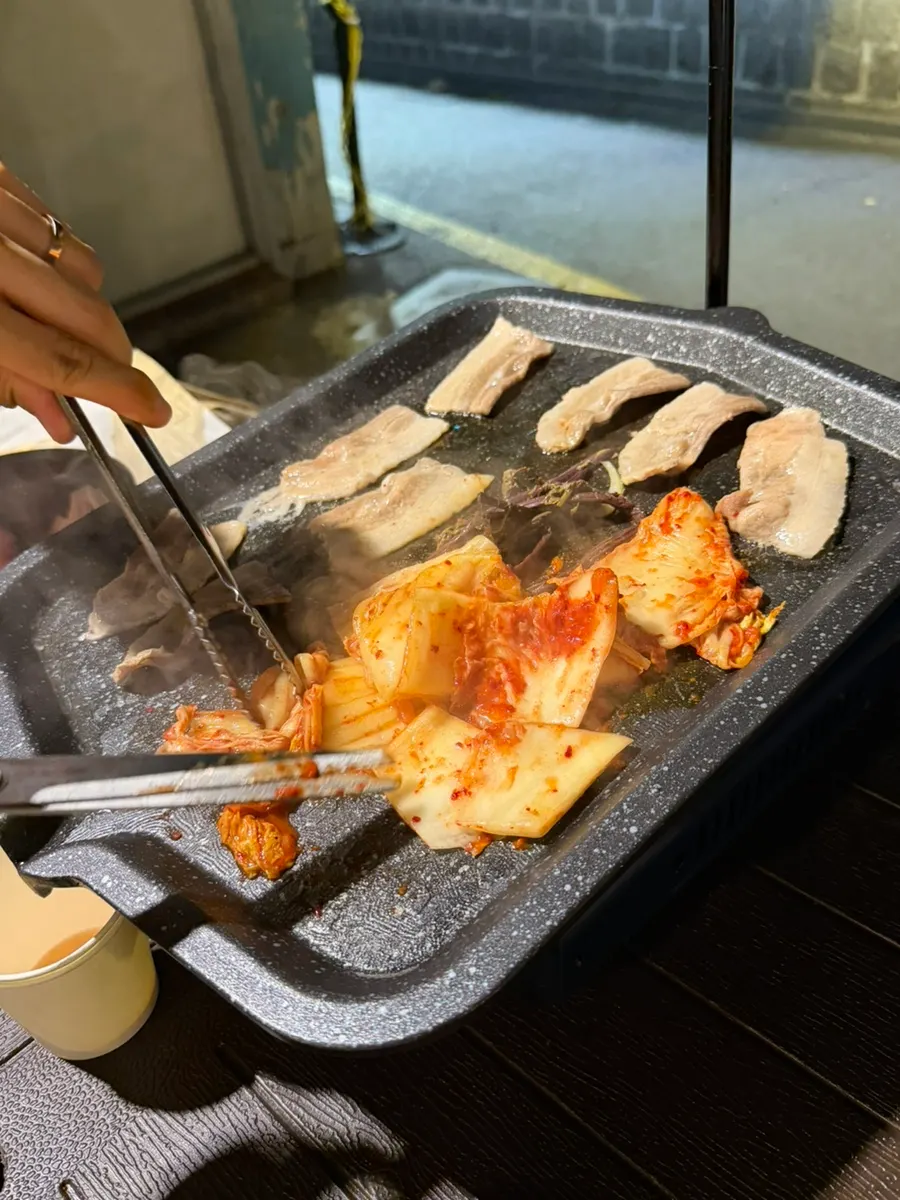 Frozen pork belly cooking on the outdoor grill