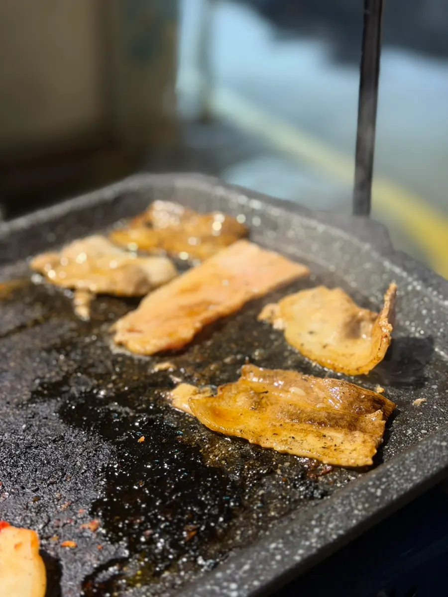 A bite combining pork belly, wasabi, and grilled kimchi