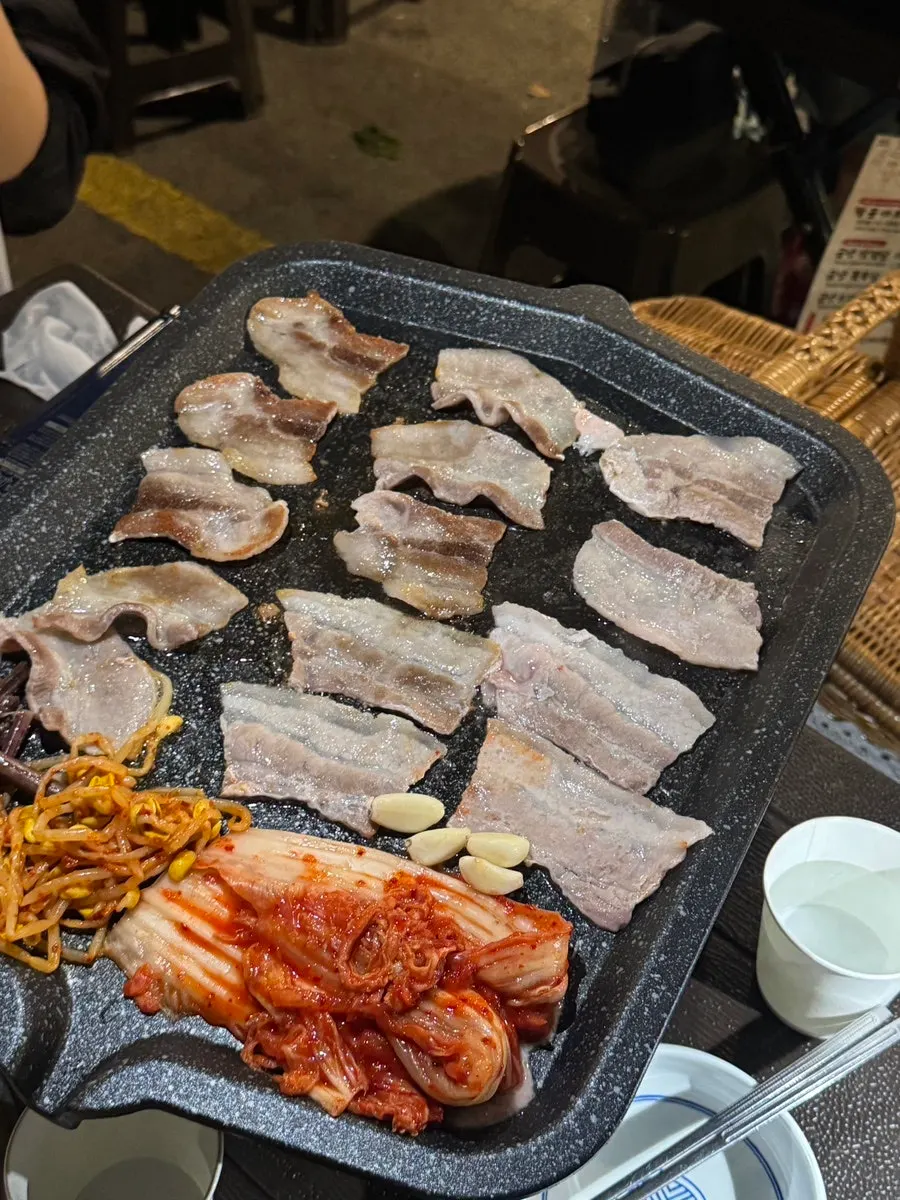 Frozen pork belly cooking on the grill
