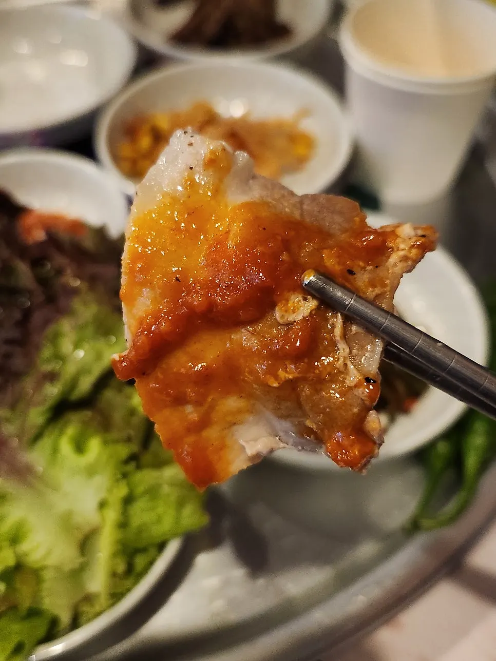 Pork belly placed on a lettuce leaf for a wrap