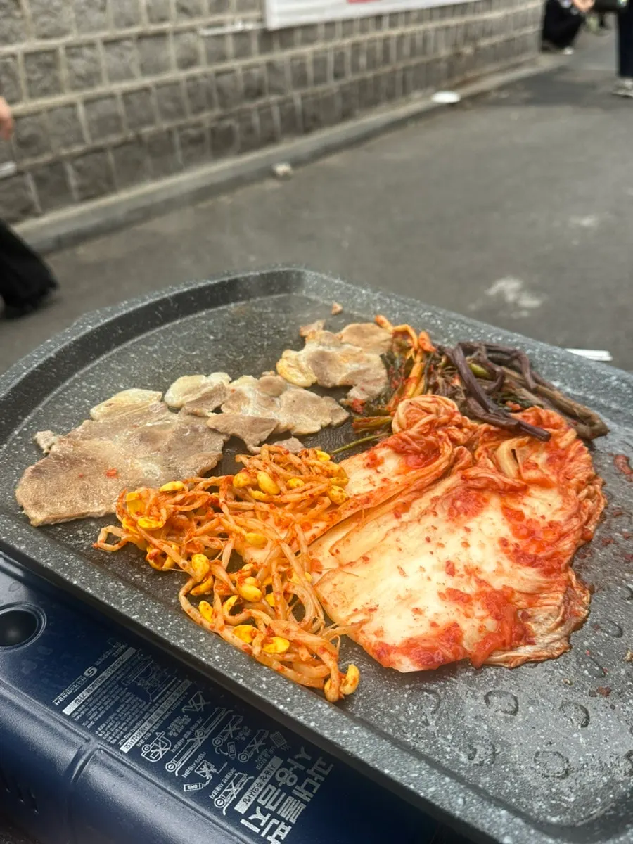 A piece of meat topped with jeotgal, wasabi, and ssamjang