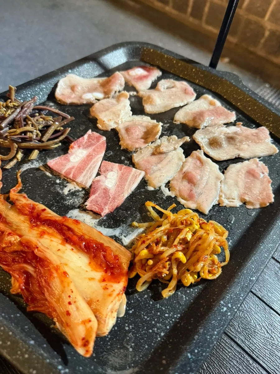 노릇하게 구워진 냉동삼겹살과 구운 김치