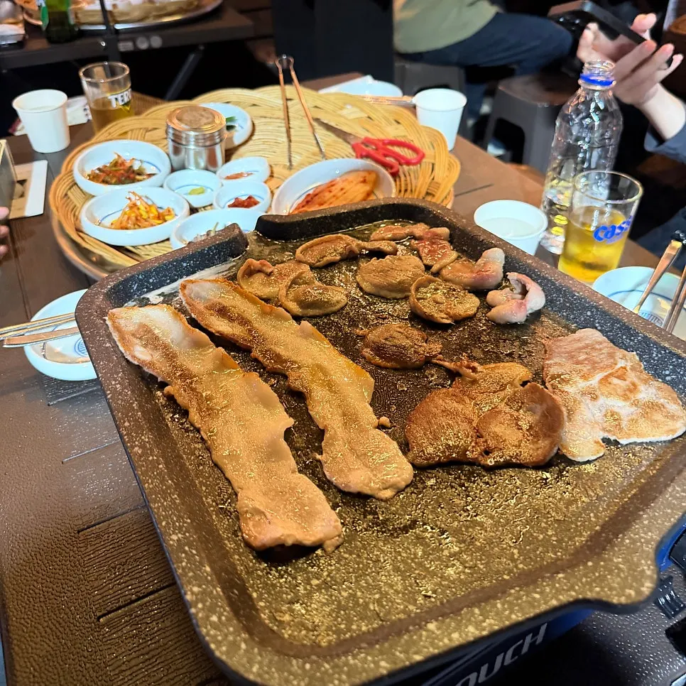 Side dishes grilling alongside the pork belly