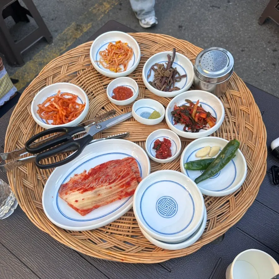Outdoor table seating facing a hanok stone wall