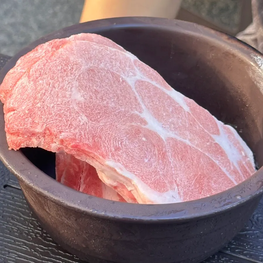 Plate of ordered thinly sliced pork belly, one serving