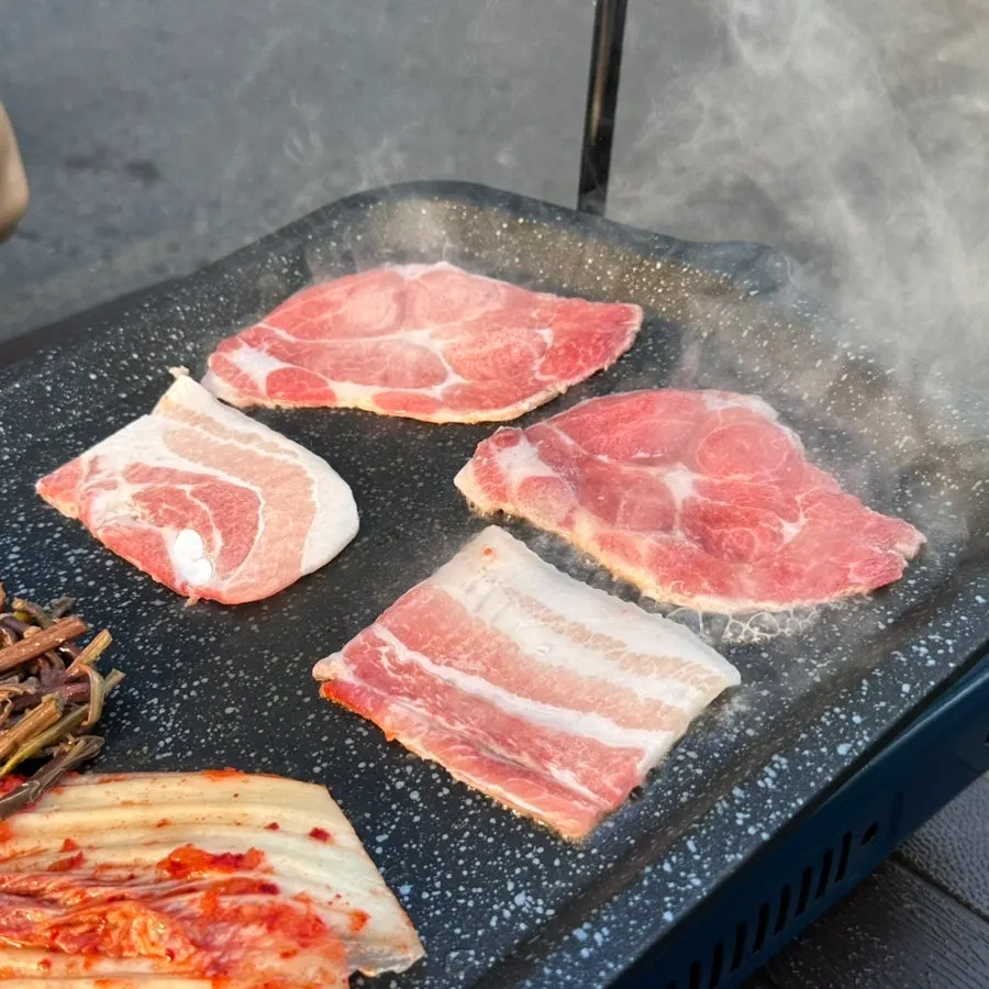 Thinly sliced pork belly placed on the outdoor grill