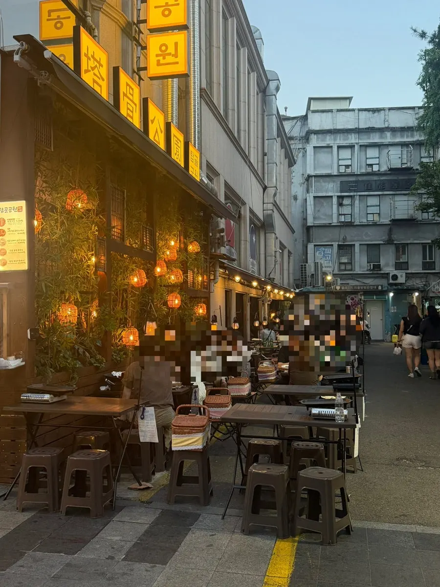 Outdoor tables laid out beneath globe lights