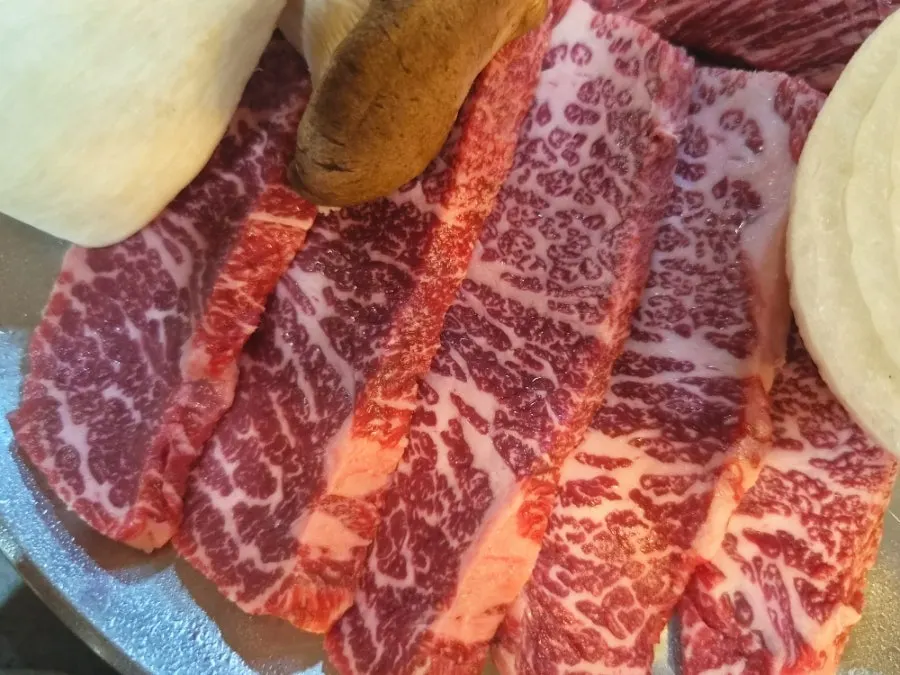 불판에 올린 와규 등심과 곁들임 양파