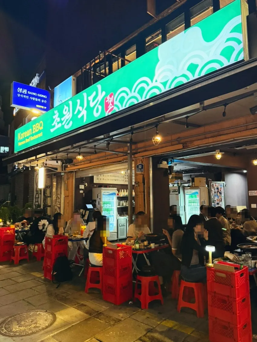 Outdoor dining restaurants lined up along the Tapgol Park stone wall