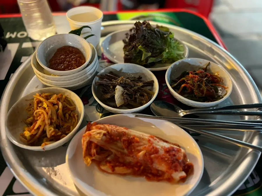 큰 쟁반에 한가득 차려진 밑반찬 상차림