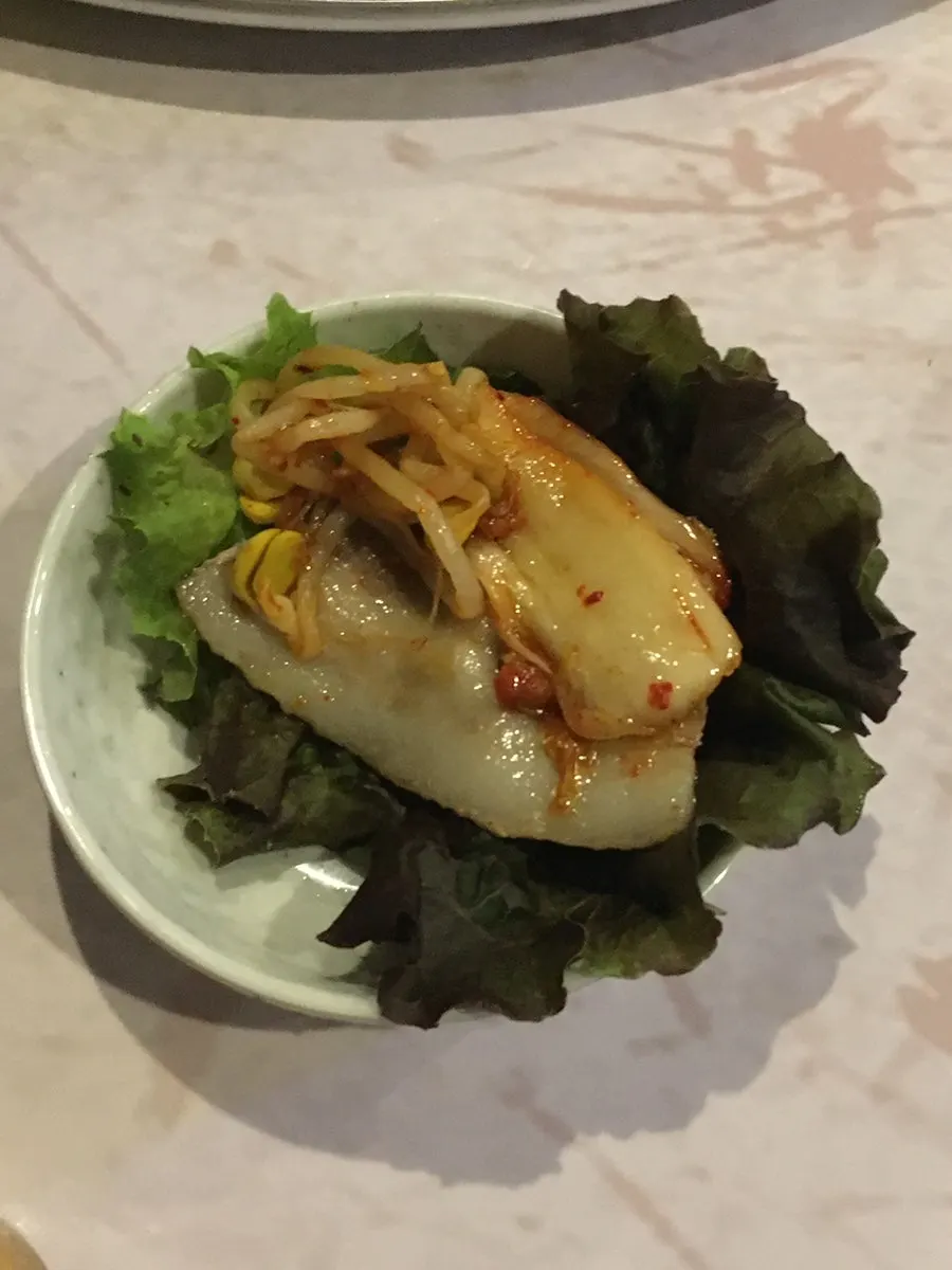 Lettuce wrap loaded with meat, kimchi, and garlic