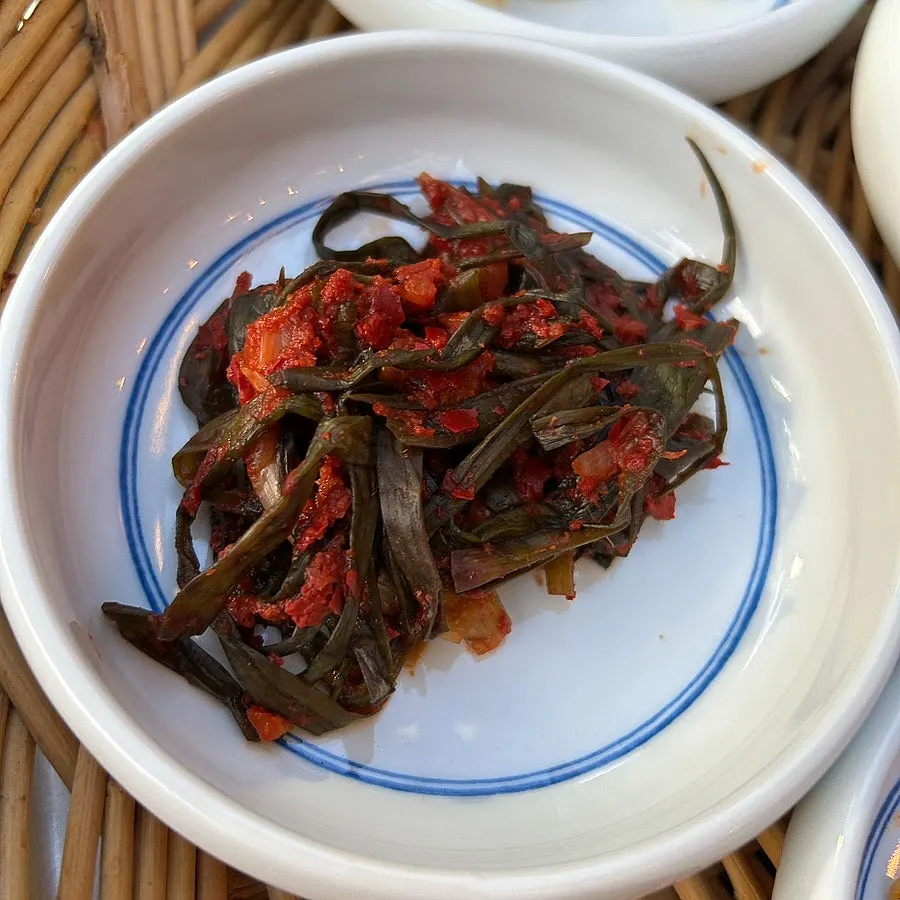 A table set with napa cabbage kimchi and side dishes