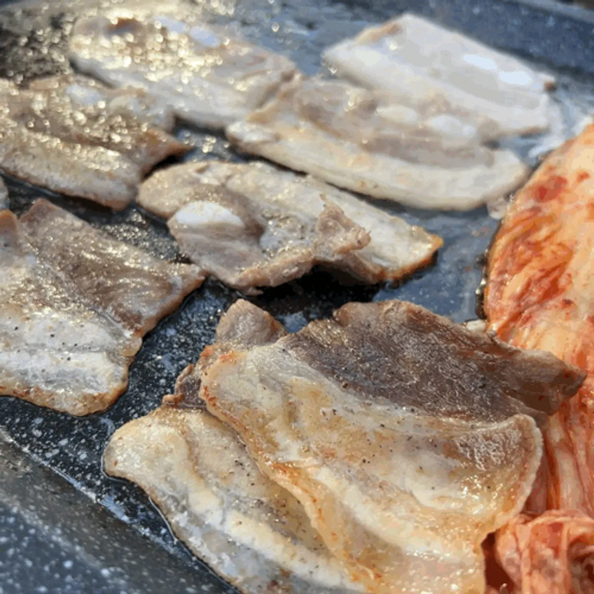 Flash-frozen pork belly sizzling on the grill