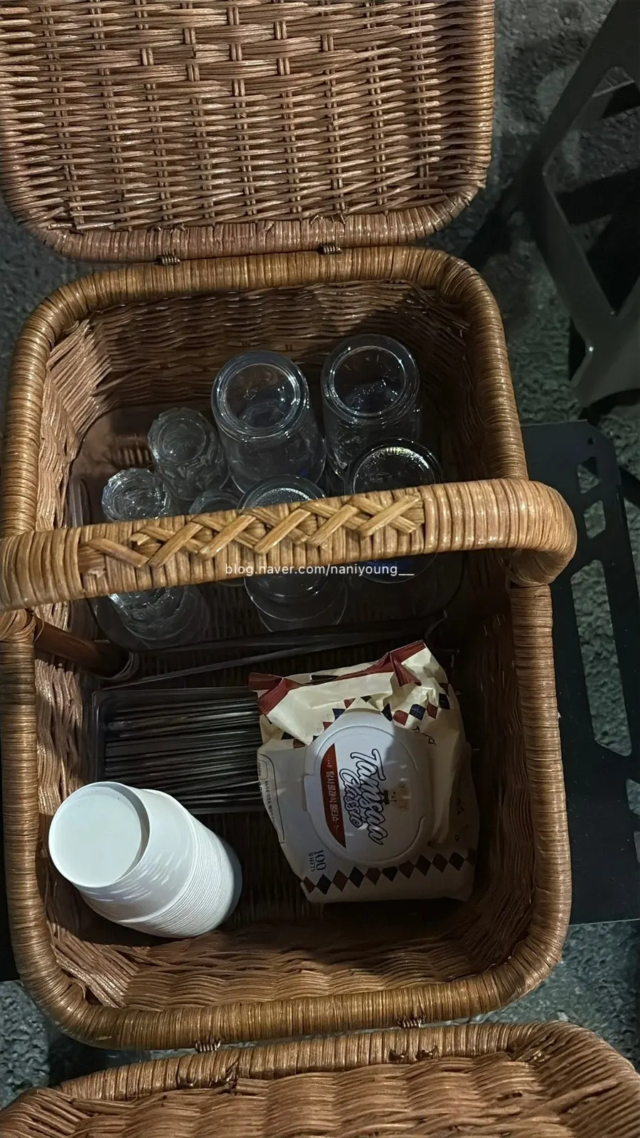 Basket beside the table holding utensils and glasses