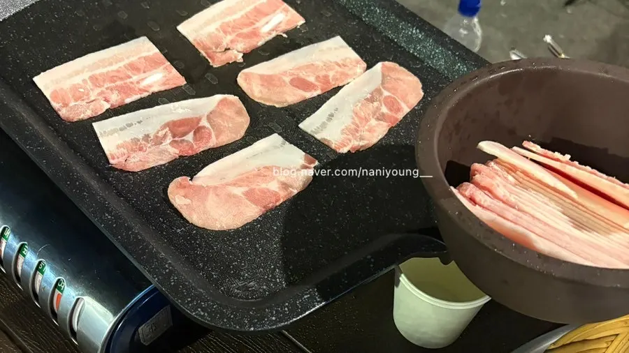 Thinly sliced frozen pork belly on the grill