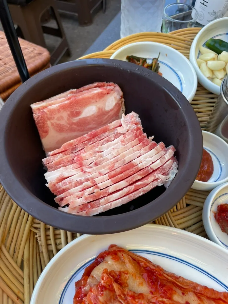 Finas láminas de naengsam cocinándose en la plancha