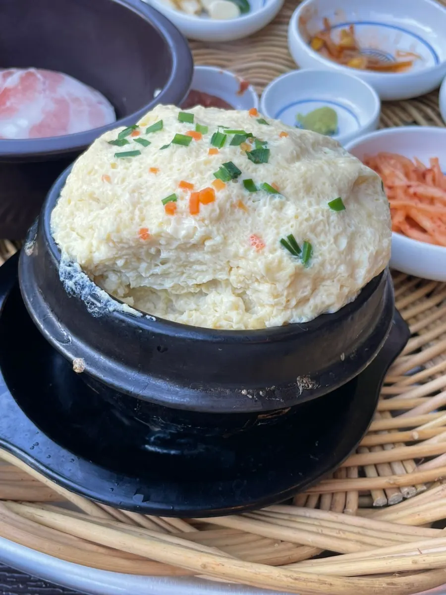 Kimchi y helechos cocinándose en el borde de la plancha