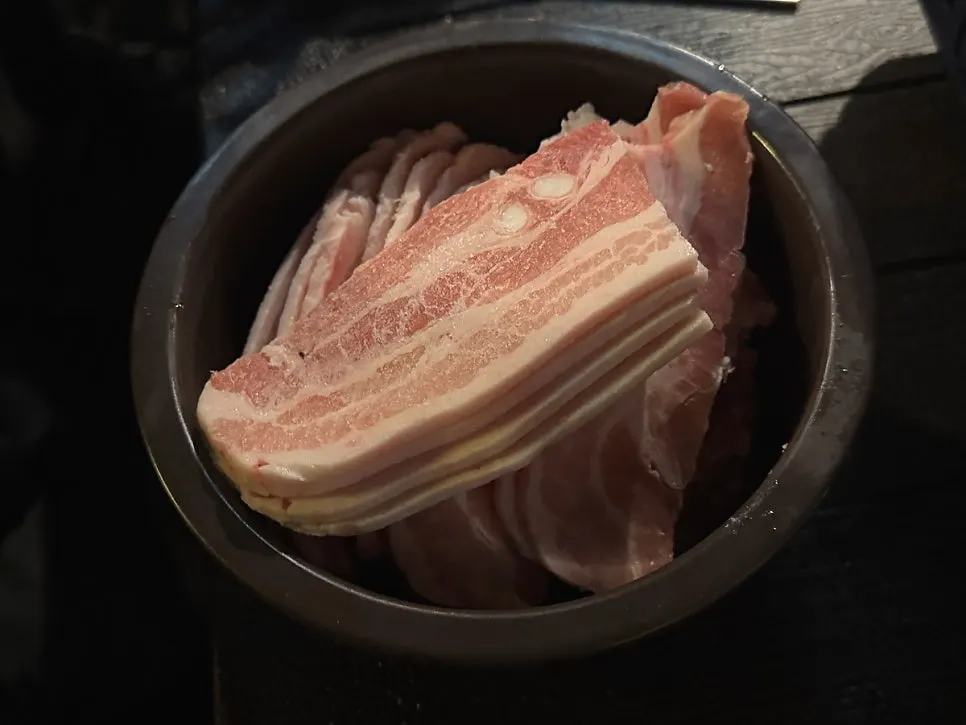 3 servings of frozen pork belly served in an earthenware bowl