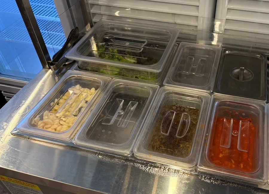 Utensils and side dishes ready at the self-serve corner