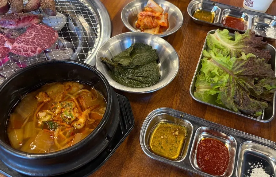 Jowatso's table loaded with side dishes and lettuce wraps