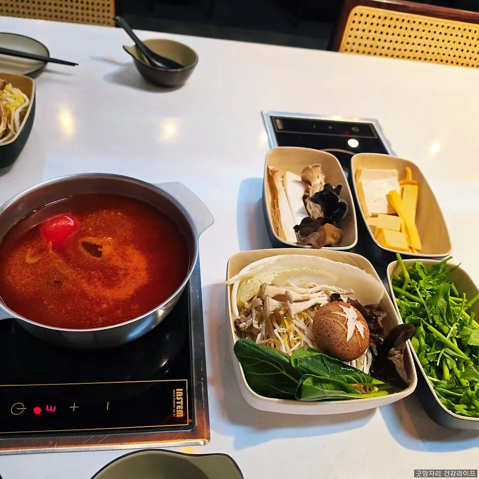 Mala broth and tomato broth pots side by side