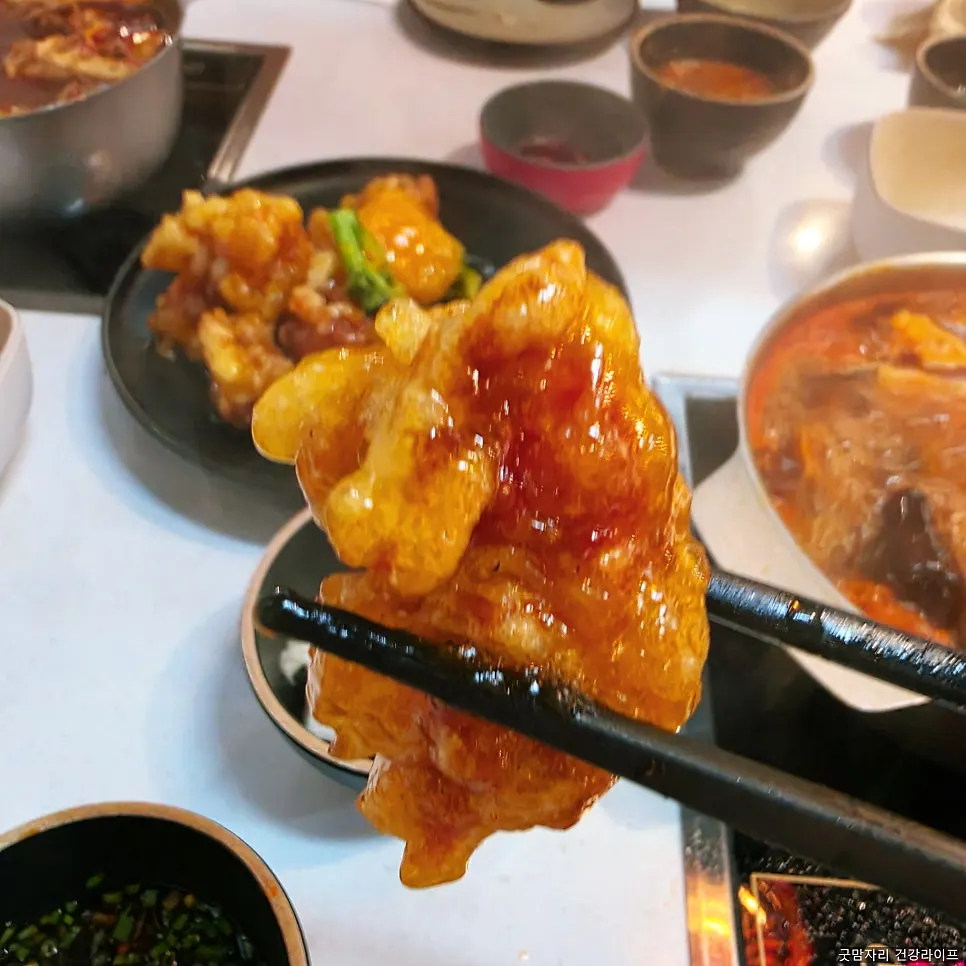 Table with orange chicken alongside hot pot