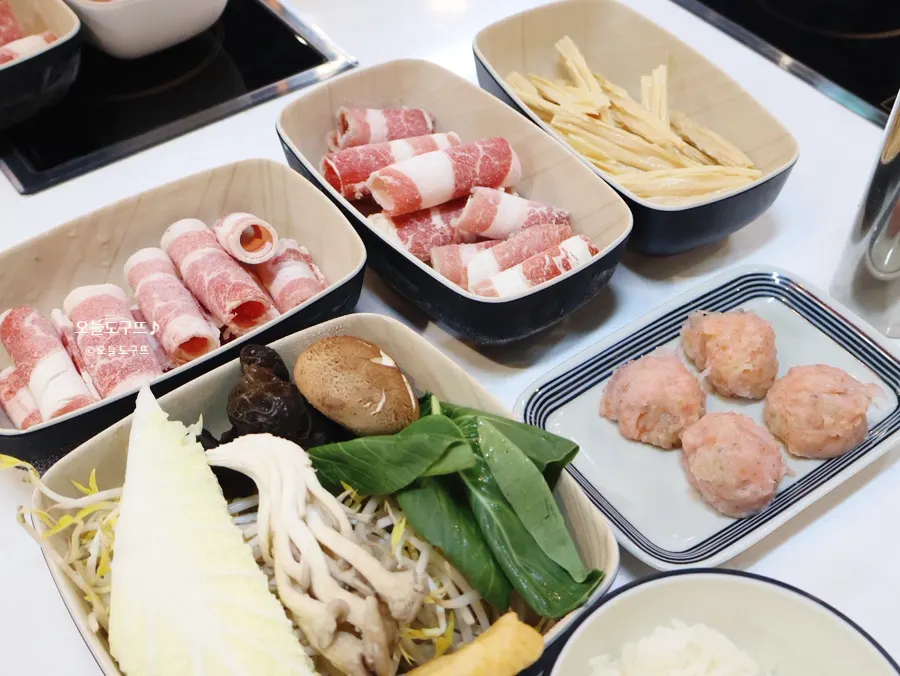 Assorted vegetables, beef brisket, fish balls, and rice included in the lunch hot pot set